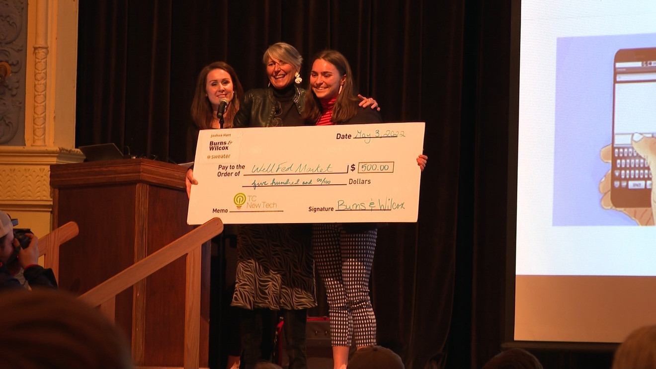 Elizabeth Saunders and teammates accepting a $500 TCNewTech funding check for Wellfed Market